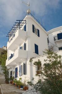 a white building with stairs leading up to it at Alkistis Apartments, 1st floor in Agios Kirykos