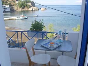 a table and chairs with a view of the ocean at Alkistis Apartments, 1st floor in Agios Kirykos