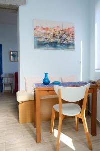 a dining room table with a chair and a painting at Alkistis Apartments, 1st floor in Agios Kirykos +21 photos