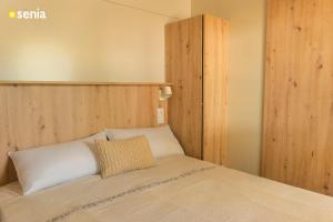 a bedroom with a bed with a wooden headboard at Sènia Botànic Bonavista in Calella