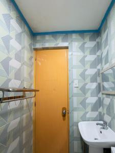 a bathroom with a yellow door and a sink at Beachside Room with Bathroom San Juan ELYU in San Juan
