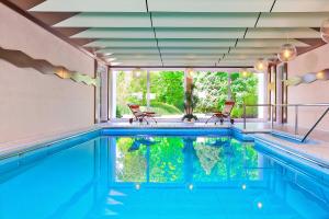 a swimming pool with two chairs and a swimming pool at Kneippkurhaus St Josef in Bad Wörishofen