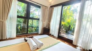 a bedroom with a bed and a large window at Ubud Tropical in Ubud +80 photos