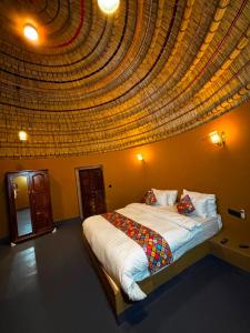 a bedroom with a large bed with a large ceiling at Urban Dhani in Gurgaon