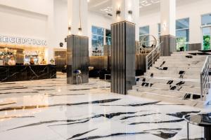 eine Lobby mit schwarz-weißen Marmorböden und -treppen in der Unterkunft Prestige Grand Hotel & Aquapark - All Inclusive in Goldstrand + 164 Fotos