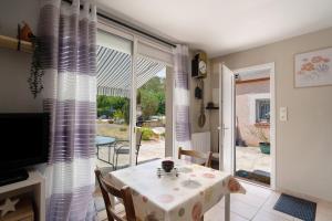 a dining room with a table and a sliding glass door at Studio Montayral in Montayral