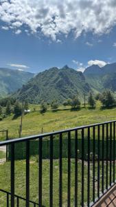 a balcony with a view of a field and mountains at Lunara Chalet in Kazbegi +17 photos