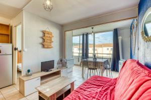 a bedroom with a red bed and a dining room at L'escale Marine Air-conditioning in Sète
