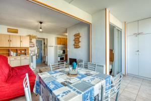 a living room with a table and a red couch at L'escale Marine Air-conditioning in Sète