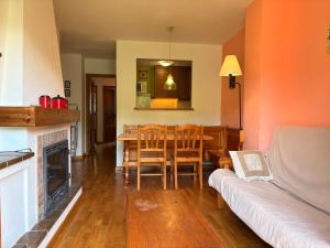 a living room with a table and a couch at Ambiente de montaña- Chimenea, vistas y jardín- Isard 4 in Pla de l'Ermita