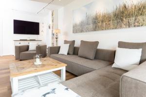 a living room with a couch and a table at Wohnung 14 Am Januspark in Juist