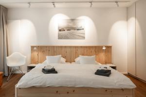 a bedroom with a large white bed and a chair at Wohnung 14 Am Januspark in Juist