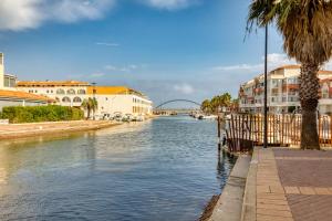 a river with buildings and a bridge in the background at L'escale Marine Air-conditioning in Sète