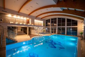 a large swimming pool in a building with an aquarium at Fala by Marena Wellness & Spa in Międzywodzie