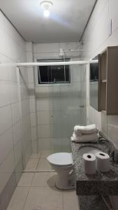 a white bathroom with a toilet and a sink at Apartamento Completo Próximo a BR in Biguaçu +5 photos