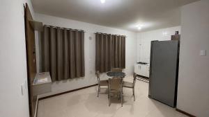 a kitchen with a table and chairs and a refrigerator at Apartamento Completo Próximo a BR in Biguaçu
