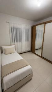 a bedroom with a bed and a large window at Apartamento Completo Próximo a BR in Biguaçu