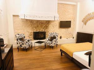 a bedroom with two chairs and a fireplace at Gite de Bourgogne in Sainte-Marie-sur-Ouche