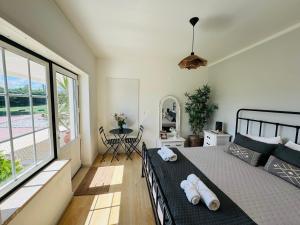 a bedroom with a bed and a large window at The Yellow Retreat in A dos Cunhados