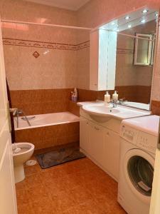 a bathroom with a tub sink and a washing machine at Garbo Appartments in Karistos +26 photos