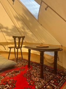 a table and a chair in a tent at KEMPINGS Kareļi in Saraiķi