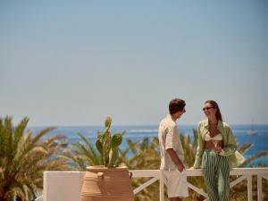 a man and a woman standing next to a fence at Golden Milos Beach Ηouse by Domotel in Provatas