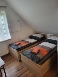 two beds sitting in a room with a wall at Penzion Podyjí in Znojmo
