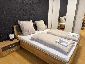 a bedroom with two beds with white sheets and a mirror at Casa del Mondo 2 in Sankt Aldegund