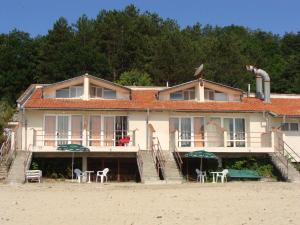 a house on the beach with tables and chairs at Letovishte Romantika in Kamchia