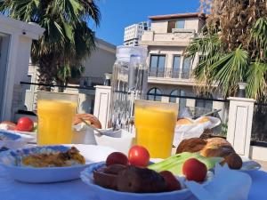 a table with food and two glasses of orange juice at Santa Maria, Vila Cerloj in Durrës