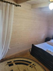 a room with a bed and a rug on the floor at Горянка in Guta +12 photos