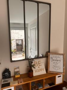 a mirror sitting on top of a wooden shelf at Gite de Bourgogne in Sainte-Marie-sur-Ouche