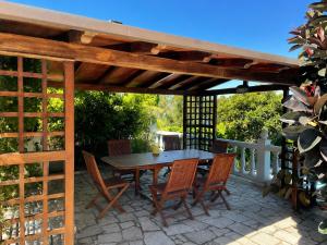 a wooden pergola with a table and chairs on a patio at Villa Aldán Areacova in Aldán