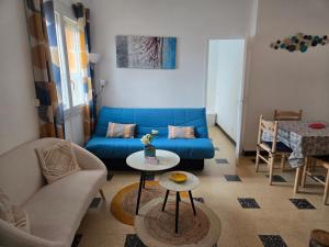 a living room with a blue couch and a table at Le 18 plage in Valras-Plage