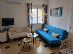 a living room with a blue couch and a table at Le 18 plage in Valras-Plage