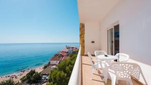 a balcony with a table and chairs and a beach at htop Caleta Palace - Bliss in Platja d'Aro