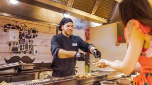 a man preparing food in a kitchen with a woman at htop Caleta Palace - Bliss in Platja d'Aro +58 photos