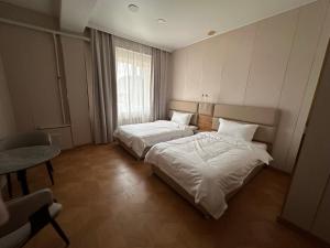 a hotel room with two beds and a window at Zarya in Ölgiy