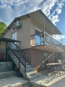 a house with a balcony and a table and chairs at Holiday home Ramovic in Virpazar +8 photos