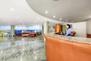 a man standing at a counter in a hotel lobby at TRH Jardín Del Mar in Santa Ponsa +50 photos