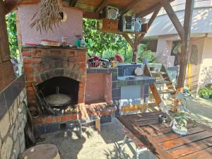 an outdoor kitchen with a brick oven and a table at Gardenhouse in Mëmëlisht