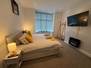 a bedroom with a bed with a television and a table at Spacious John York House & Parking in Doncaster