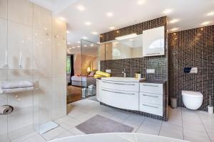 a bathroom with a sink and a toilet and a mirror at Exklusive Traumvilla mit Sauna in Hamburg +35 photos