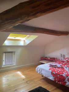 an attic bedroom with a bed and a window at chambre deux personnes, lit pour Bébé in Verlhac-Tescou +26 photos