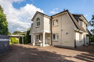 a large house with a brick driveway at Exklusive Traumvilla mit Sauna in Hamburg