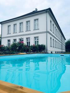 a building with a swimming pool in front of it at Gutshaus Groß Helle in Mölln