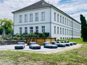 a large white building with blue pillows in front of it at Gutshaus Groß Helle in Mölln +114 photos