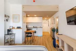 a room with a bed and a kitchen and a table at Studio Home Madrid in San Sebastián de los Reyes