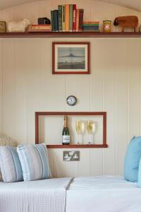 a bedroom with a bed and two glasses of wine at Lens Hut in Masbury Station