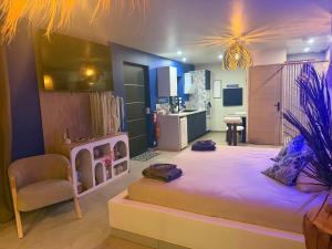 a bedroom with a large bed and a kitchen at gîte romantique in Etalondes-la-Pipe